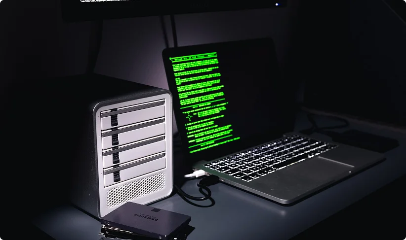 A laptop displays green terminal text beside a second device showing server information.